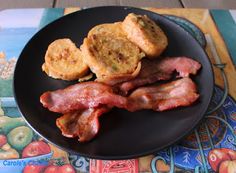 a plate full of bacon and fried potatoes on a place mat next to a book