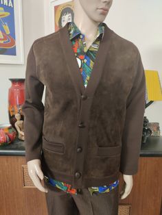 This is a rare find brown machine knit jacket with a suede leather front . It was made by Pierre Sangan of Jersey British Isles. The jacket is cardigan style, collarless with a V neck, four button closure with a spare inside the jacket should you loose one. It has two hip pockets. The condition is very good. The measurements are Chest 112cm Sleeves shoulder to cuff approx 65cm Length shoulder to hem 68cm Brown Single Breasted Sweater Coat With Long Sleeves, Brown Single Breasted Sweater Coat, Brown Single-breasted Long Sleeve Sweater Coat, Classic Brown Cardigan With Button Closure, Brown Workwear Cardigan With Pockets, Brown Cardigan With Pockets For Work, Fitted Brown Cardigan For Fall, Classic Fitted Brown Cardigan, Brown Buttoned Cardigan For Fall