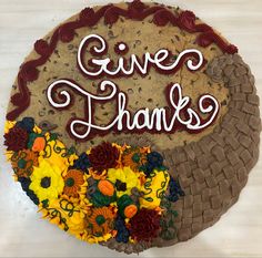 a cake with flowers and the words give thanks written on it