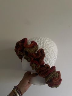 a hand is holding up a crocheted hat