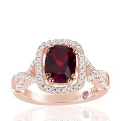 This ring features an elongated cushion-cut created ruby center stone, prong-set in a pave white cubic zirconia halo. This ring is crafted in rose over sterling silver. So much gorgeous detail gives this ring beauty and shine from every single angle. The white pave halo continues down the band of the ring to create a crossover "X" design on both sides of the centerstone. The luscious mix of ruby colors in a bed of rose sterling silver gives this ring a tasteful appeal that you just cannot resist Louis Vuitton Baby, Ancient Royalty, Queen Of The South, Pink Engagement Ring, Gemstone Brooch, Franklin Tennessee, Cubic Zirconia Engagement Rings, Cubic Zirconia Bracelet, Book Appointment