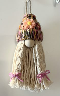 a white wall hanging with a flower on it's head and tassels