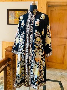 Embroidered Coat , Kashmiri Jacket  Description Allow yourself to be lost in the lush flora of Kashmir's enchanted forests every time you wear the Long Kashmiri Jacket. This Kashmiri embroidered jacket is crafted in 100% pure wool/ Pure Raw Silk and . This festival season, you'll be warmed by not just the luxurious fabric but also by our artisans' love for their craft.  ● 100% Pure wool / Pure raw Silk ● Crafted in Kashmir ● Traditionally embroidered by our artisans ● Can Also Be Customised In c Embroidery Indian, Boho Coat, Embroidered Coat, Aari Work, Jacket For Women, Indian Outfit, Embroidered Jacket, Clothes Collection, Raw Silk