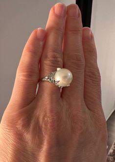 Materials: Platinum Ring Size: 6.25  Hallmarks: D009 Pt900  Total Weight (grams): 7.80  Primary Stone(s) Type: Cultured Pearl  Primary Stone(s) Shape: Near-Round  Primary Stone(s) Dimensions: 11.60 mm - approximate (very large pearl - significant in size) Primary Stone(s) Gemologist Note: White with pink and green overtone and the Cultured Pearl has excellent luster.  Secondary Stone(s) Type: Diamond  Secondary Stone(s) Shape: Round Brilliant Cut  Secondary(s) Stone Dimensions: 1.50 - 1.60 mm  T Exquisite White Gold Pearl Ring With Diamond Accents, Luxury Polished Pearl Ring, Classic Oval Pearl Ring With Diamond Accents, Timeless White Gold Pearl Ring With Polished Finish, White Gold Pearl Ring With Center Stone, Formal White Diamond Gemstone Ring, Classic Diamond Pearl Ring Hallmarked, Classic Brilliant Cut Pearl Ring Gift, Classic Brilliant Cut Pearl Ring As Gift