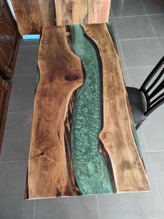 a wooden table with a river running through it on top of tile flooring in a kitchen