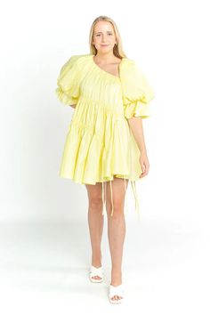 This gorgeous little dress by Aje is perfect for a special occasion or event. This style features Aje's signature voluminous sleeves and asymmetric hemlines in a summery lemon-hue. Pair it with low white heels for a formal look or sneakers for a casual setting. This style runs large so we recommend choosing one size down. Perfect for race days, weddings, vineyards, birthdays and daytime events. Mini length Intricately gathered Asymmetric neckline and hem Signature Aje voluminous sleeve Fully lined Spring Yellow Asymmetrical Mini Dress, Yellow Asymmetrical Summer Dress, Aje Dress Pink, A-line Mini Dress With Ruffle Hem For Daywear, Aje Dress Orange, Cardigan Sweater Jacket, White Heels, Gothic Dress, Boho Maxi Dress