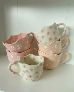 five cups are stacked on top of each other in the shape of hearts and flowers