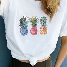 a woman wearing a white shirt with three pineapples on the front and bottom