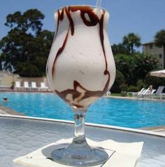 an ice cream sundae sitting on top of a table next to a swimming pool