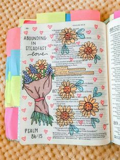 an open bible with flowers on it