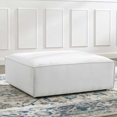 a white ottoman sitting on top of a rug