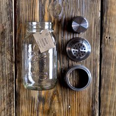 a mason jar sitting on top of a wooden table next to an empty canister