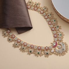 Description A stunning mélange of Mughal motifs from the north with guttapusallu style from southern India, Mahnaz is a handcrafted heirloom necklace, perfect for celebrations. Falling long, the piece features floral nuances and iconic crescents that meet at a lotus bud. Pink and green kempu stones along with uncut polkhis are set in Jadau style, accentuated by a pearl border. Clusters of rice pearls add traditional fervor to this necklace bearing testament to the artistic prowess of our artisan Elegant Zari Work Necklace For Eid, Festive Chandbali Necklaces For Diwali, Navratri Chandbali Necklaces, Navratri Festive Chandbali Necklaces, Elegant Festive Necklaces With Motifs, Traditional Long Temple Necklace With Intricate Design, Chandbali Necklace For Celebrations And Festivals, Chandbali Necklaces For Celebrations And Festivals, Festive Chandbali Necklaces For Celebration