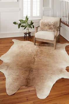 a living room with a chair and a cow hide rug