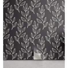 a black and white floral wallpaper with leaves on the back, in front of a dark background