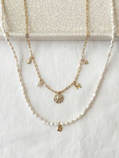 Create your own personalized keepsake charm necklace! This is a custom necklace you will adore for years to come! All charms, chains, and accents, are made with long lasting, non tarnish, and 100% sensitive skin safe 14K Gold Filled with genuine gemstones and freshwater pearls. 🤍HOW TO ORDER🤍 1. Choose Number of Charms, Chain Style, and Chain Length from the drop down menu. 2. Write the name of the charms in the Personalization section below in the order you would like your charms to hang from left to right. You may also include any notes about spacing of the charms in this section as well!  All orders will have centered charms and even spacing unless otherwise specified. Example: Butterfly, Heart, Shell, Rose Quartz 14K Gold Filled Chain Styles: Long Short (1.8mm) Mini Paperclip (2x5mm) Cheap Yellow Gold Charm Necklace For Birthday, Cheap Charm Choker Necklaces With Delicate Chain, White Charms Necklace For Birthday Gift, White Charm Necklace For Birthday, White Initial Pendant Necklace For Birthday Gift, White Initial Pendant Necklace For Birthday, Personalized White Charms Necklaces, Personalized Charm Necklace, Custom Charm Necklaces