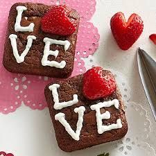 two heart shaped brownies with white frosting and strawberries