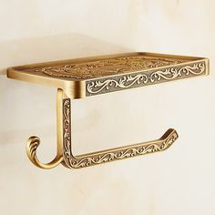 an ornate gold shelf with two hooks on it