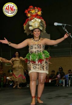 a woman in a hula skirt and headdress on stage