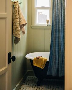 a bath tub sitting next to a window in a bathroom