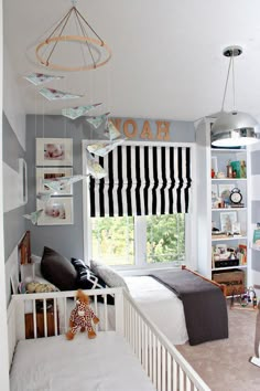 a child's bedroom with black and white striped drapes hanging from the ceiling