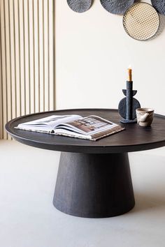 a round table with magazines and vases on it