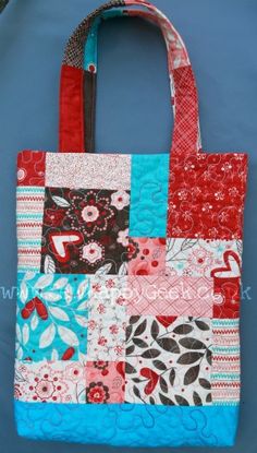 a red, white and blue patchwork tote bag sitting on top of a table