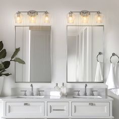 a bathroom with two sinks and three mirrors