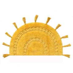 a yellow rug with tassels on the bottom and an oval design in the middle