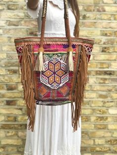 Extra large beaded leather bag handmade from genuine leather in tan brown and multicoloured embroidery. This is an oversize women's shoulder bag ideal to be used as shopper, leather tote bag, beach bag or summer tote bag. It has been hand crafted from recycled Indian vintage tribal tapestry, hand beaded with glass beads and decorated with leather fringe. Amazing craftmanship and a unique piece like no other. Please note that these bags are extremely time consuming to make as the leather is braid Bohemian Satchel Hobo Bag For Shopping, Artisan Shoulder Bag With Tassels For Everyday, Bohemian Shoulder Bag With Braided Handles For Shopping, Bohemian Large Capacity Hobo Bag For Shopping, Bohemian Handmade Hobo Bag For Shopping, Bohemian Brown Hobo Bag For Shopping, Rectangular Hobo Bag With Tassels For Shopping, Bohemian Hobo Bag With Leather Handles For Shopping, Brown Bohemian Hobo Bag For Shopping