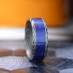 a blue and silver ring sitting on top of a table