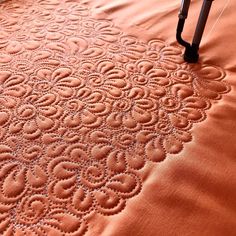 an orange table cloth with circles on it and a black chair in the back ground