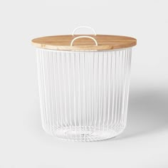 a white wire basket with wooden lid