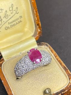 14ct white gold ruby and diamond cocktail ring  This stunning ring boasts a proud set oval 1.16ct natural ruby (8x6) complimented by a tapered pave set diamond band comprising of 1.02ct natural cut diamonds  Ring size: M(UK), 6(USA) Ring weight: 6.67grams  Sale Price: £1210.00 Insurance replacement price: £2850.00 All articles come presented in a gift box Gia Certified Oval Ruby Ring, Oval Ruby Ring With Vvs Clarity Diamond, Oval Ruby Ring With Diamond, Hallmarked Oval Diamond Gemstones, Heirloom Oval Ruby Ring Gia Certified, Gia Certified Heirloom Oval Ruby Ring, Heirloom Oval Gia Certified Ruby Ring, Oval Ruby Ring With Diamond Cut In Platinum, Classic Oval Platinum Gemstones