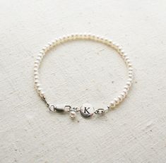 Bridesmaid Bracelet, Pearl Bracelet, Initial Bracelet, Personalized Jewelry, Bridesmaid Gift There are oodles of pearls on these bracelets. They make a lovely gift for your bridesmaids. One that they can wear well after your wedding day! + Small Freshwater Pearls (size of pearls are approx. 3mm) Sterling Silver Initial & Lobster Clasp. + Initial: Pick upon checkout. + Bracelet Length: Pick upon checkout. + Your jewelry will come in a jewelry box, tied with a ribbon, ready for gift giving. Th Classic Personalized Adjustable Pearl Bracelet, Personalized Adjustable Classic Pearl Bracelet, Classic Adjustable Personalized Pearl Bracelet, Elegant Silver Name Bracelet With Round Beads, Elegant Adjustable Bridesmaid Bracelets, Classic Personalized Pearl Bracelet, Personalized Classic Pearl Bracelet, Personalized Round Bead Pearl Bracelet In Elegant Style, Elegant Personalized Round Bead Pearl Bracelet