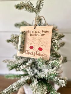 a christmas ornament hanging from the top of a tree with money on it