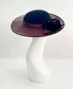 "Classic vintage hat. Perfect for Ascot, weddings, special occasions, very elegant. Comes with elastic to hold hat in place. Condition: vintage perfect Colour: black and dark burgundy Label: Made in England Material: polyester Size: M inner circumference aprox. 21.5-22 inches, circumference 44\"\" *Please note all hats come securely packed in a box *All our vintage items come in clean and best condition possible *Please note all hats come securely packed in a box *All our vintage items are top q Vintage Black Wide Brim Costume Hat, Evening Adjustable Cloche Hat With Curved Brim, Adjustable Cloche Hat With Curved Brim For Evening, Vintage Black Cloche Hat For Evening, Black Brimmed Hat For Vintage Events, Wide Brim Cloche Hat For Evening, Adjustable Cloche Hat With Wide Brim For Evening, Adjustable Wide Brim Cloche Hat For Evening, Formal Cloche Hat For Royal Ascot With Curved Brim