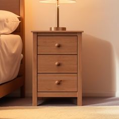 a nightstand with a lamp on it next to a bed