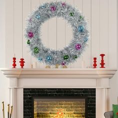 a decorated christmas wreath on top of a fireplace