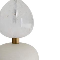 a white table lamp with a gold base and clear glass ball on it's top