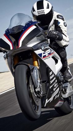 a man riding on the back of a motorcycle down a road