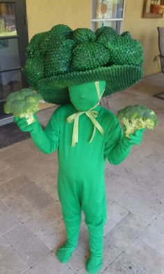 a person in a green costume holding broccoli