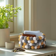 a desk with a potted plant on it and a card holder in the middle