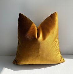 a yellow pillow sitting on top of a white table