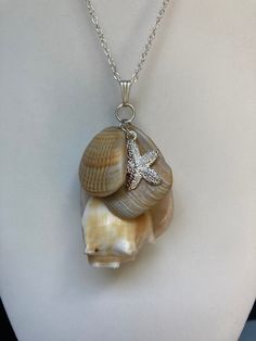 "Sea shell pendant necklace, ocean shells clustered with all different types of shells, a Sterling plated Starfish charm on a sterling silver plated 20\" loop chain 3mm X 2.3mm. Unique seashell pendant measures 2 3/4\" X 1 1/2'' includes bail in measurement  You can compare the size of the shells to the $0.50 cent piece in the pictures. All my necklaces are different and would be considered one of a kind. View my collection of Kingman Arizona Turquoise here: https://www.etsy.com/shop/MoonwaterJewelryShop?section_id=28192591  I've been selling on eBay since 2003 Came to Etsy to sell jewelry. Returns and exchange details ► RETURNS / EXCHANGES All items are handcrafted and custom pieces therefore we don't usually accept returns or exchanges on jewelry unless the fault was ours. Screens do not Ocean-inspired Jewelry With Starfish Charm And Shell Shape, Shell-shaped Ocean-inspired Jewelry With Starfish Charm, Ocean-inspired Shell Pendant Necklace With Lobster Clasp, Ocean-inspired Shell Jewelry With Starfish Charm, Shell Starfish Charm Necklace, Sterling Silver Starfish Charm Pendant Necklace, Silver Shell Jewelry With Pearl Charm, Silver Shell Necklaces With Pearl Charm, Sterling Silver Pendant Necklace With Starfish Charm