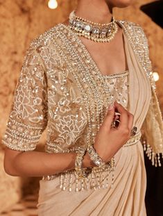 Embrace opulence in this golden ensemble featuring a short cape jacket adorned with intricate floral embroidery. The drape sari is elegantly finished with an embroidered border and a coordinating belt, adding a touch of glamour. The padded blouse, with a concealed zip on the back, ensures a seamless fit. Step into luxury with this gorgeous outfit that seamlessly blends traditional elegance with contemporary style. Gold Organza Saree, Saree Cape, Heavy Blouses, Drape Sari, Golden Blouse Designs, Diwali Dress, Golden Blouse, Gold Organza, Saree Jackets