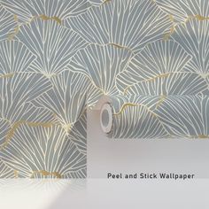 a wallpaper with gold and silver leaves on it, next to a roll of tape