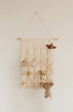 a stuffed animal is hanging on the wall next to a cloth board that has several small pieces of fabric attached to it