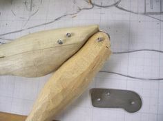 a wooden object sitting on top of a table next to a knife