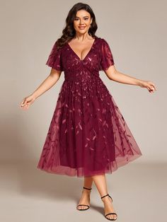 a woman in a red dress is posing for the camera with her arms outstretched and hands out